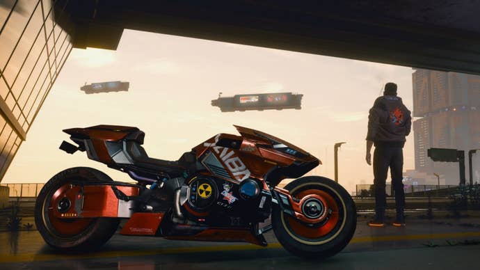 A character in Cyberpunk 2077 looks out at the sky in Night City in the background. In the foreground is a parked motorcycle.