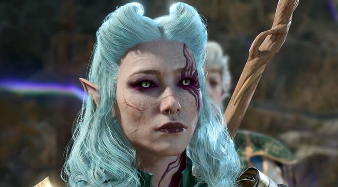 An femine elven character in Baldur’s Gate 3, with pale blue hair, scarred face and a purple tattoo whisping out like smoke from her eye, looks up at the camera with a forlorn expression.