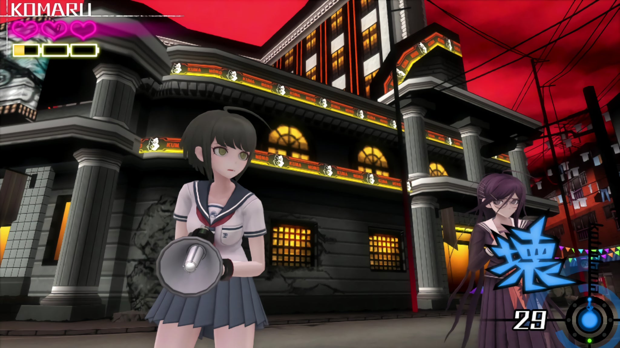 Komaru clutches her bullhorn-style gun and looks fearful as she and Toko stand in front of a city building. - 3
