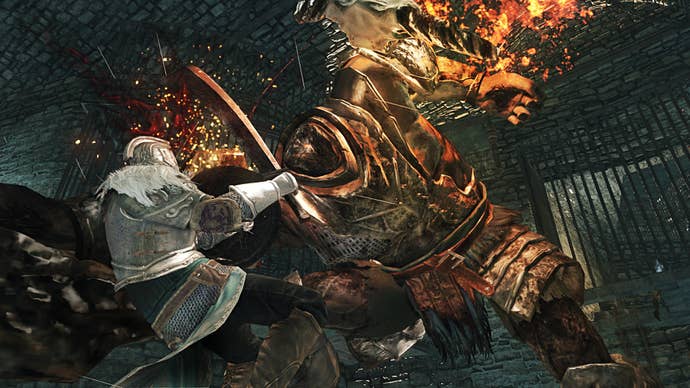 A huge armoured enemy smashes through a warrior’s shield in Dark Souls 2.