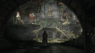 A person wearing a hood is stood in a sanctuary with stone statues of various figures on pedestals displayed around it in Dark Souls Archthrones.