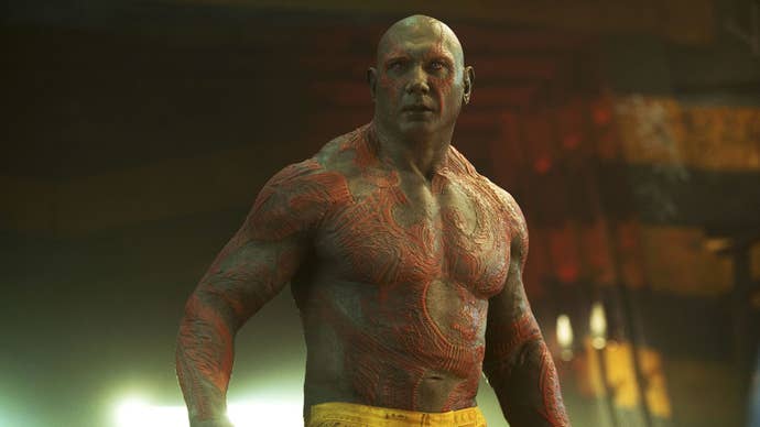 Dave Bautista as Drax is stood shirtless in a prison, wearing only prison trousers.
