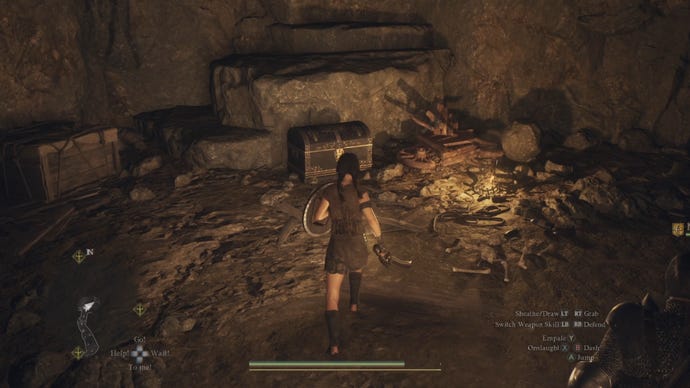The player heads towards a chest resting against a cave wall in Dragon's Dogma 2.