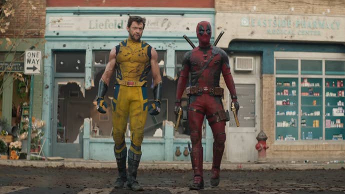 Wolverine and Deadpool are working along a street, buildings behind them slightly destroyed, Wolverine’s suit damaged in Deadpool & Wolverine.