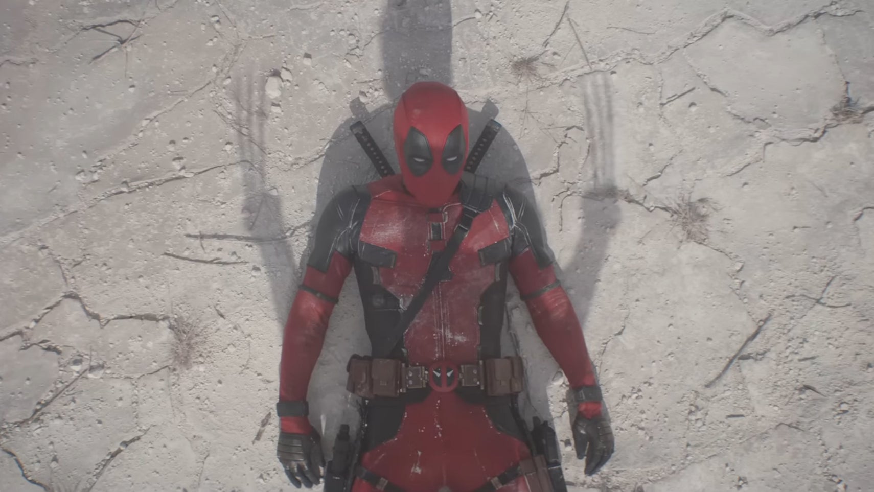 Deadpool is laying on the ground, looking up at Wolverine, who's shadow can be see over Deadpool. - 1