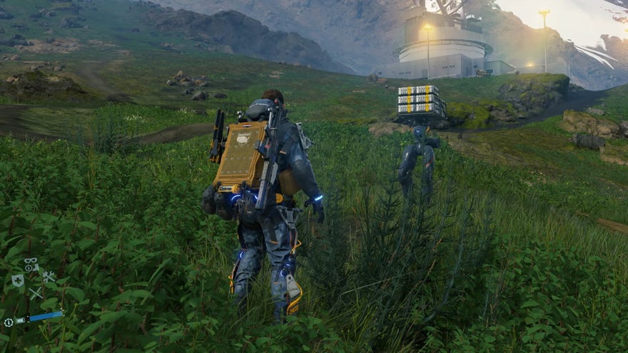 Sam looks at Buddy Bot walking up to him on a grassy mountainside in Death Stranding Director’s Cut