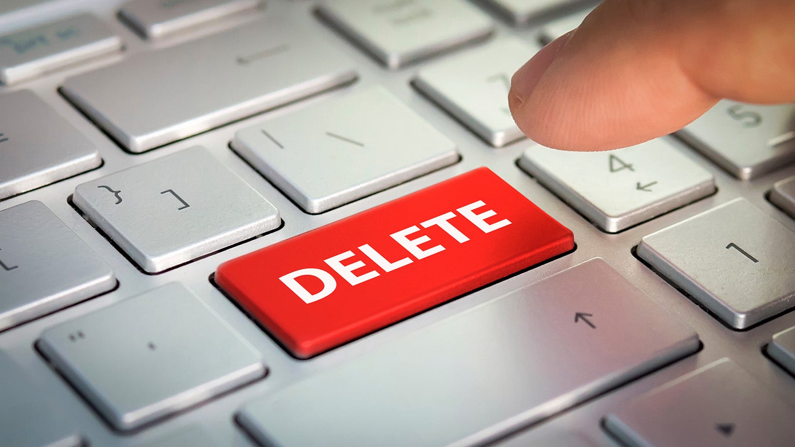 A close-up of a finger about to press a red "delete" button on a keyboard. A button I know well.