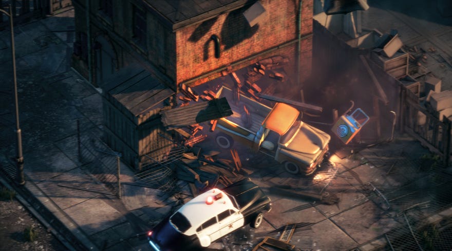 A truck crashes through a brick building as a police car tries to intercept.
