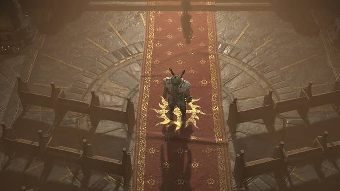 Diablo 4 Donan’s Favor: A man wearing a green skirt and a green turban is standing on a long red carpet, emblazoned with a golden sunburst