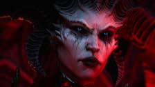 Diablo 4 Traveler's Superstition: A biatch wit heavy eye makeup n' multiple horns sproutin from her had is starin offscreen, her grill illuminated by crimson light
