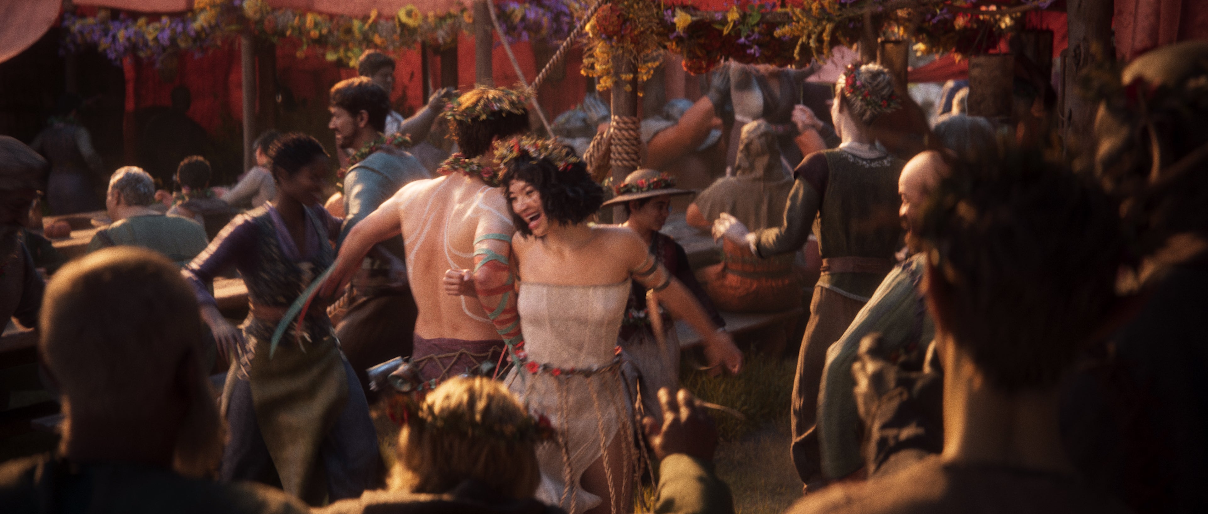 People dancing with floral wreaths at a drunken festival from the new Divinity game.