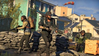 A screenshot from The Division: Heartland showing three armed players positioned along a quaint smalltown US street.