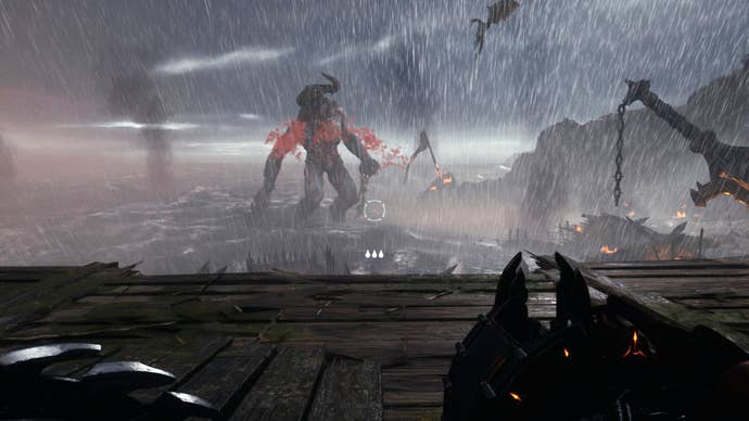 The player in Doom: The Dark Ages stands on a ledge overlooking a beach and watches a Titan demon fighting a Dragon in the distance near the end of Chapter 1.