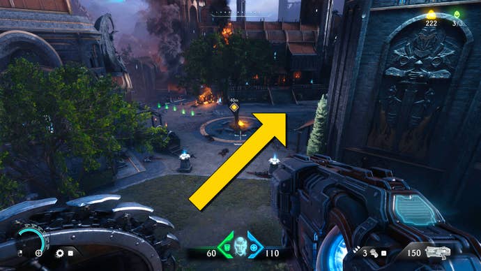 The player in Doom: The Dark Ages looks down from an upper ledge towards a small group of buildings around a tree in a circular section of street.