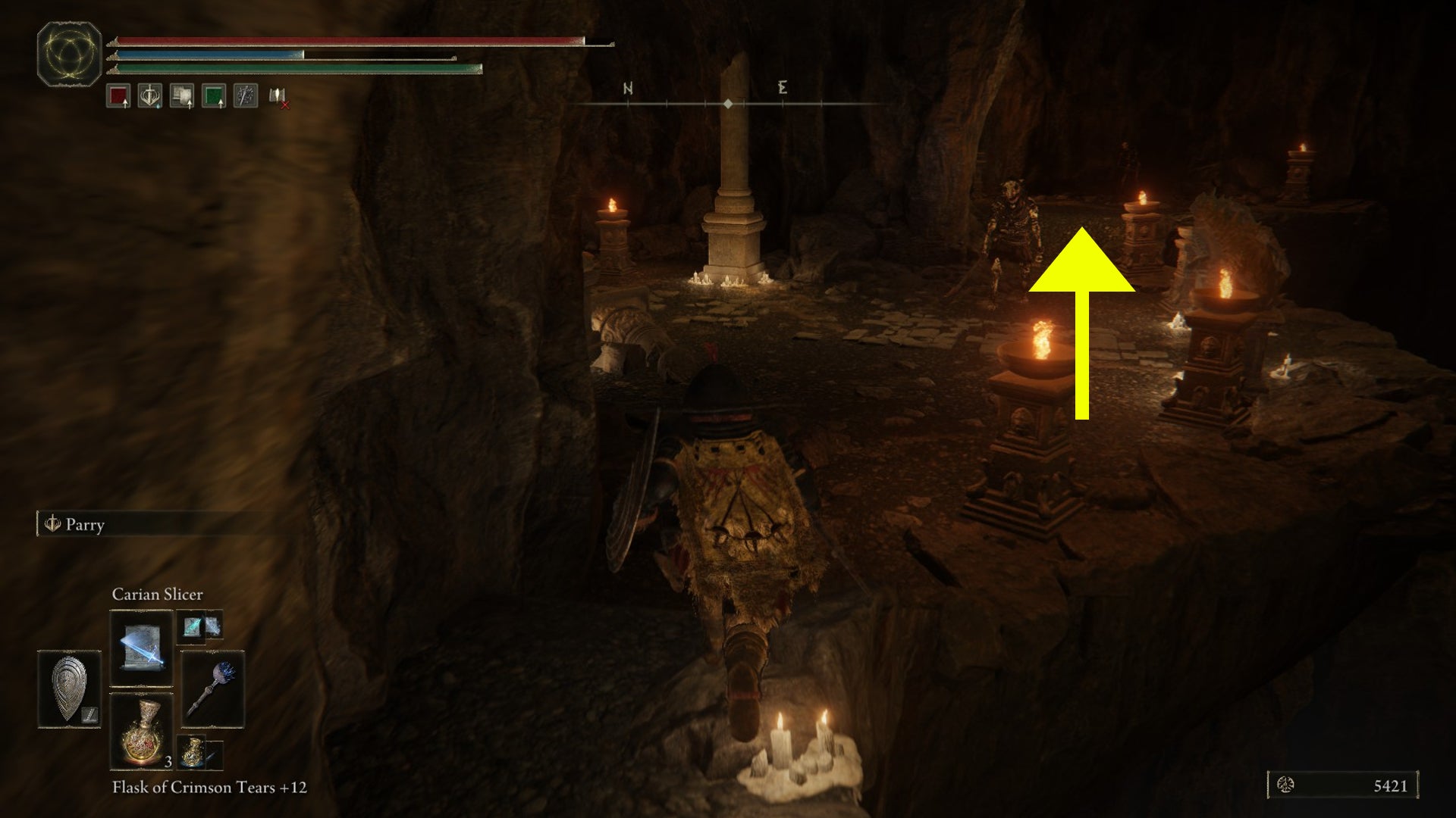 A screenshot with a yellow arrow past a skeletal enemy, showing where to go in the Dragon's Pit dungeon in Elden Ring: Shadow of the Erdtree. - 5