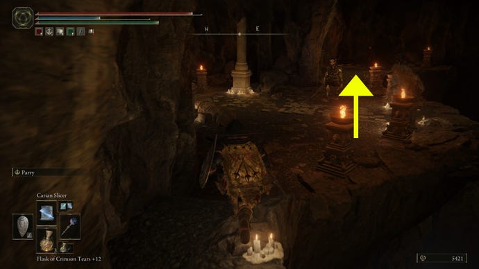 A screenshot with a yellow arrow past a skeletal enemy, showing where to go in the Dragon's Pit dungeon in Elden Ring: Shadow of the Erdtree.
