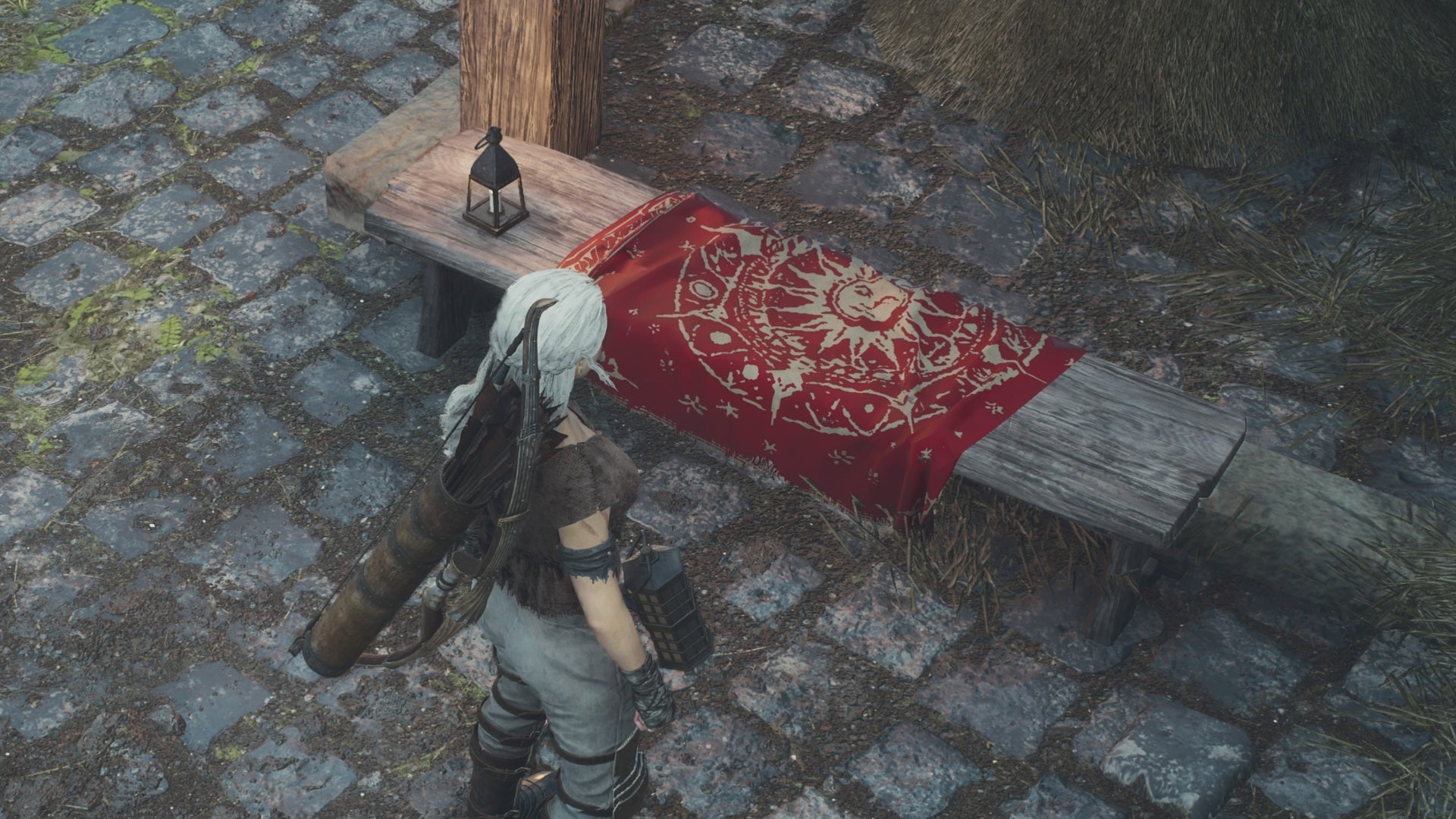 dragons dogma, a white haired arisen is facing a special seat for resting and dozing that&rsquo;s covered in a red blanket.