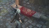 dragons dogma, a white haired arisen is facing a special seat for resting and dozing that's covered in a red blanket.