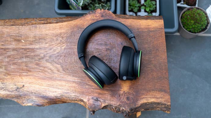 Microsoft’s Xbox Wireless Headset sitting on a wooden bench outside with plants visible in the background