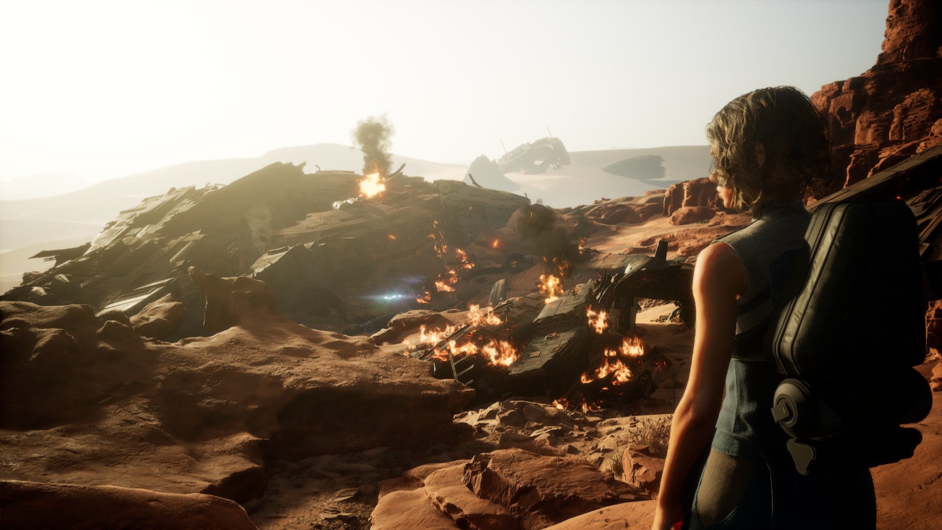 A player character gazes out at a field of fiery wreckage in Dune Awakening. - 1