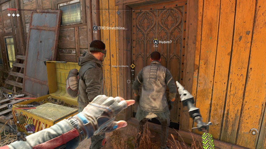 The player stands behind two other humans, controlled by other players, as they enter a building in Dying Light 2’s co-op mode