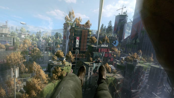 A promotional screenshot from a preview of Dying Light 2, showing the protagonist’s first person view of ziplining to the roof of a skyscraper. Trees and plants have begun to grow on all the buildings in the city