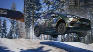 A Ford WRC rally car flying through the air after a jump on a snowy racetrack