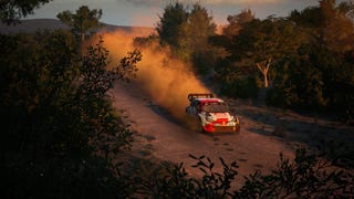 A Toyota WRC rally car racing down a dirt track with a trail of dust spraying behind it
