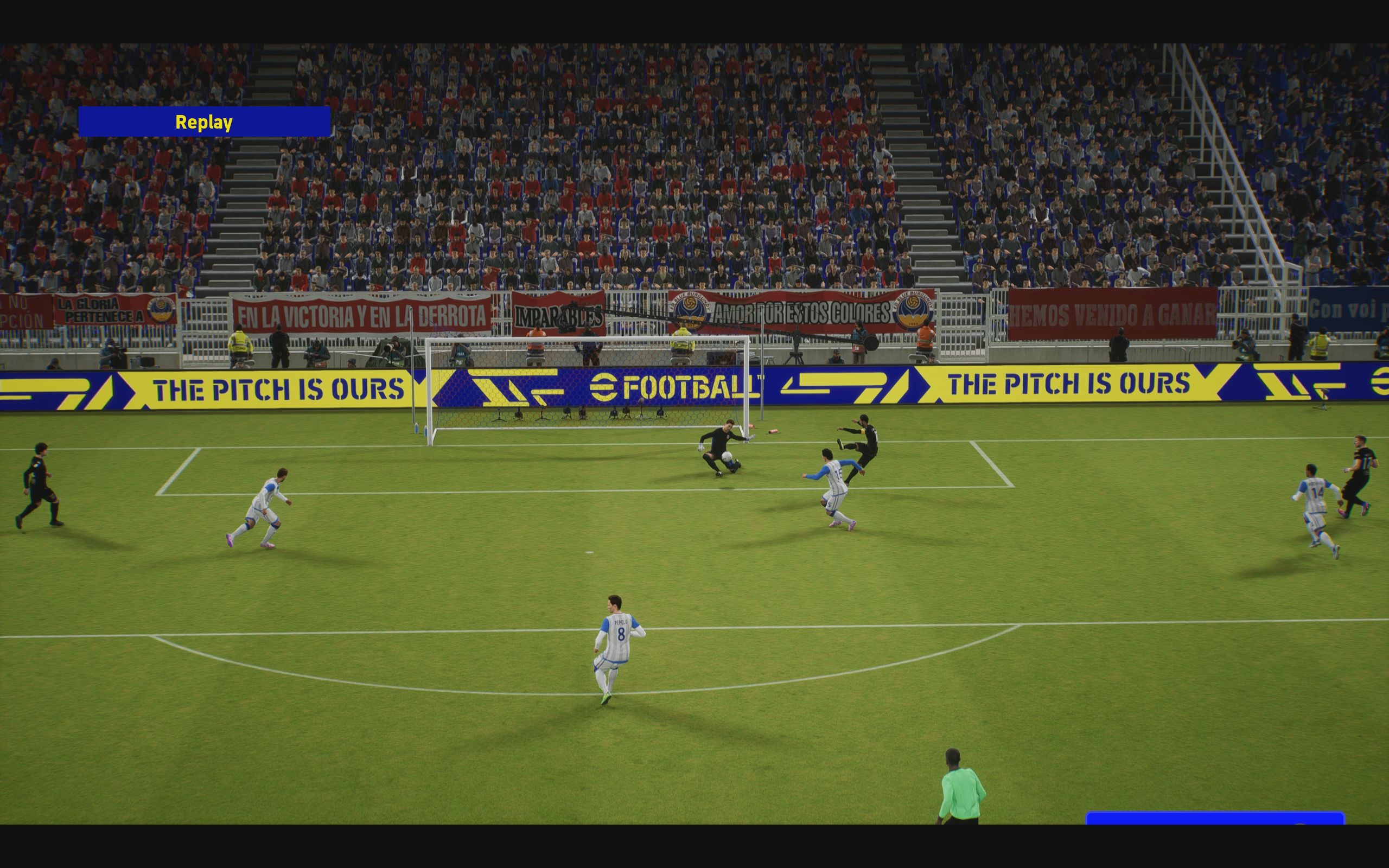 eFootball review: A replay of a goalkeeper saving a close-range shot with his body, camera facing the goal head-on, with the shot to the low-right of the goal.