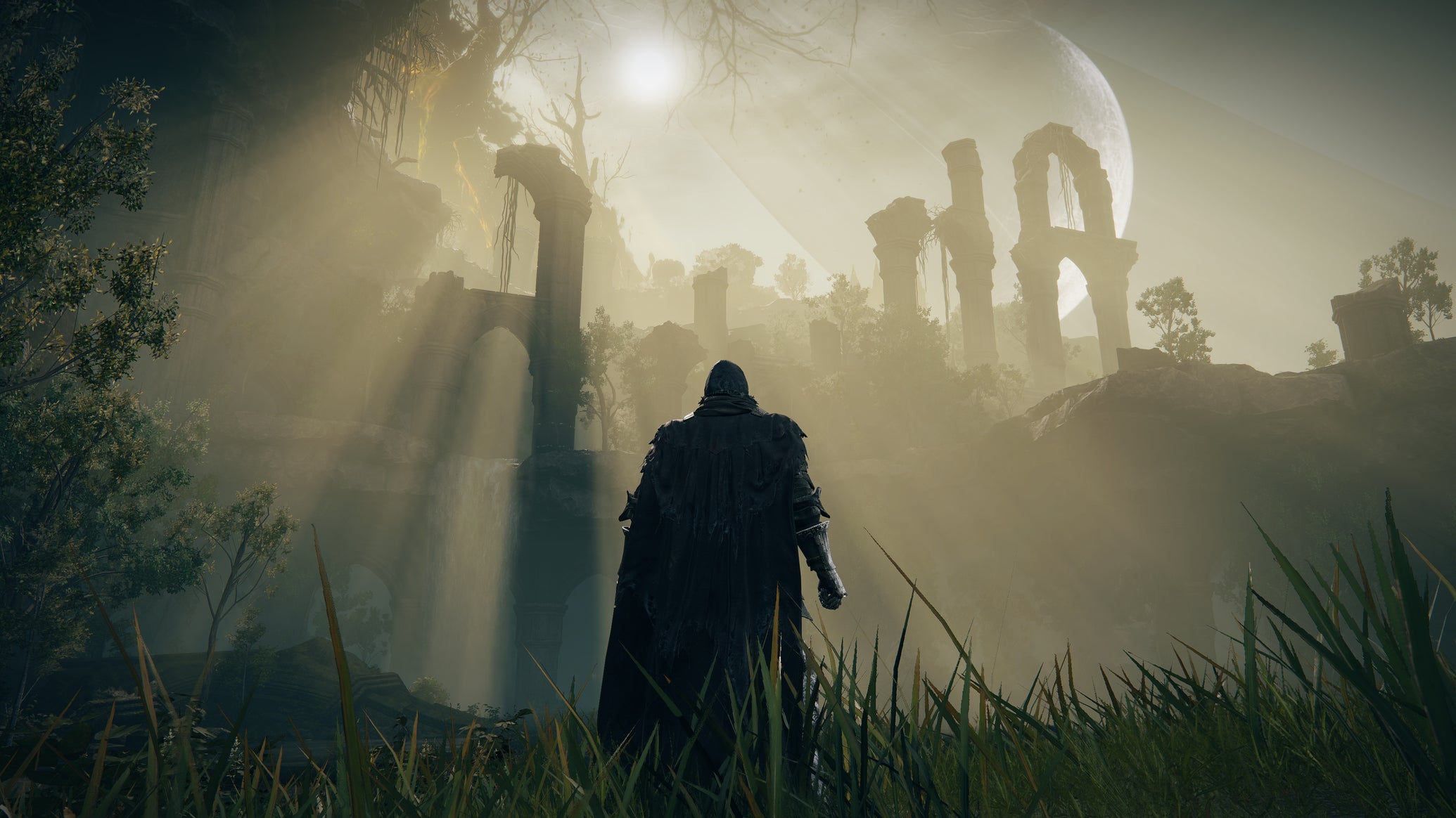 The player in Elden Ring: Shadow Of The Erdtree stands surveying the Ancient Ruins Of Rauh, bathed in sunlight. - 1