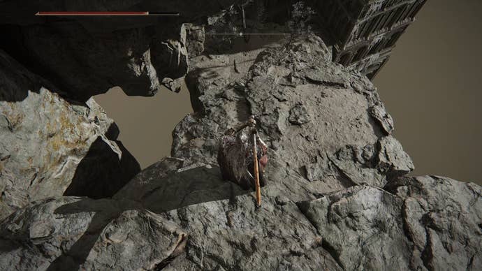 A warrior looks down at a lower platform in Crumbling Farum Azula in Elden Ring.