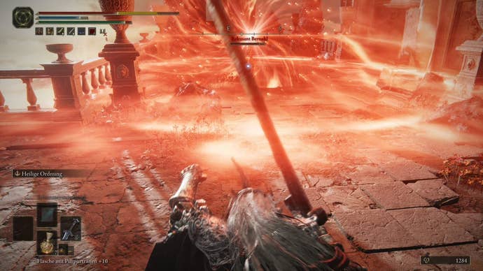 A warrior gets hit by a large red energy attack from Recusant Bernahl in Crumbling Farum Azula in Elden Ring.