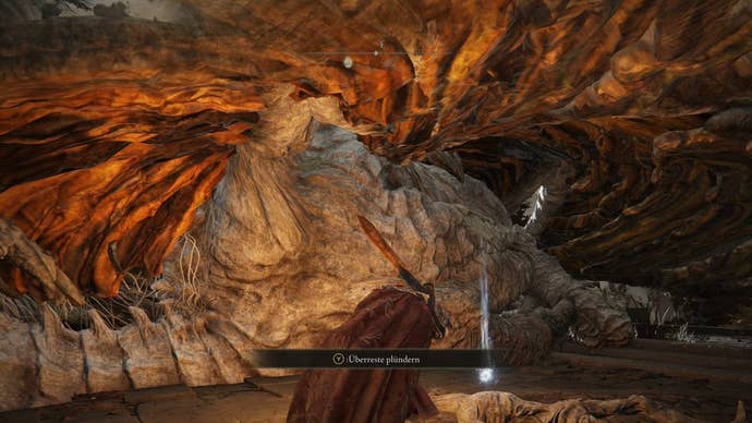A warrior creeps under a sleeping dragon’s wing to claim an item in Crumbling Farum Azula in Elden Ring.