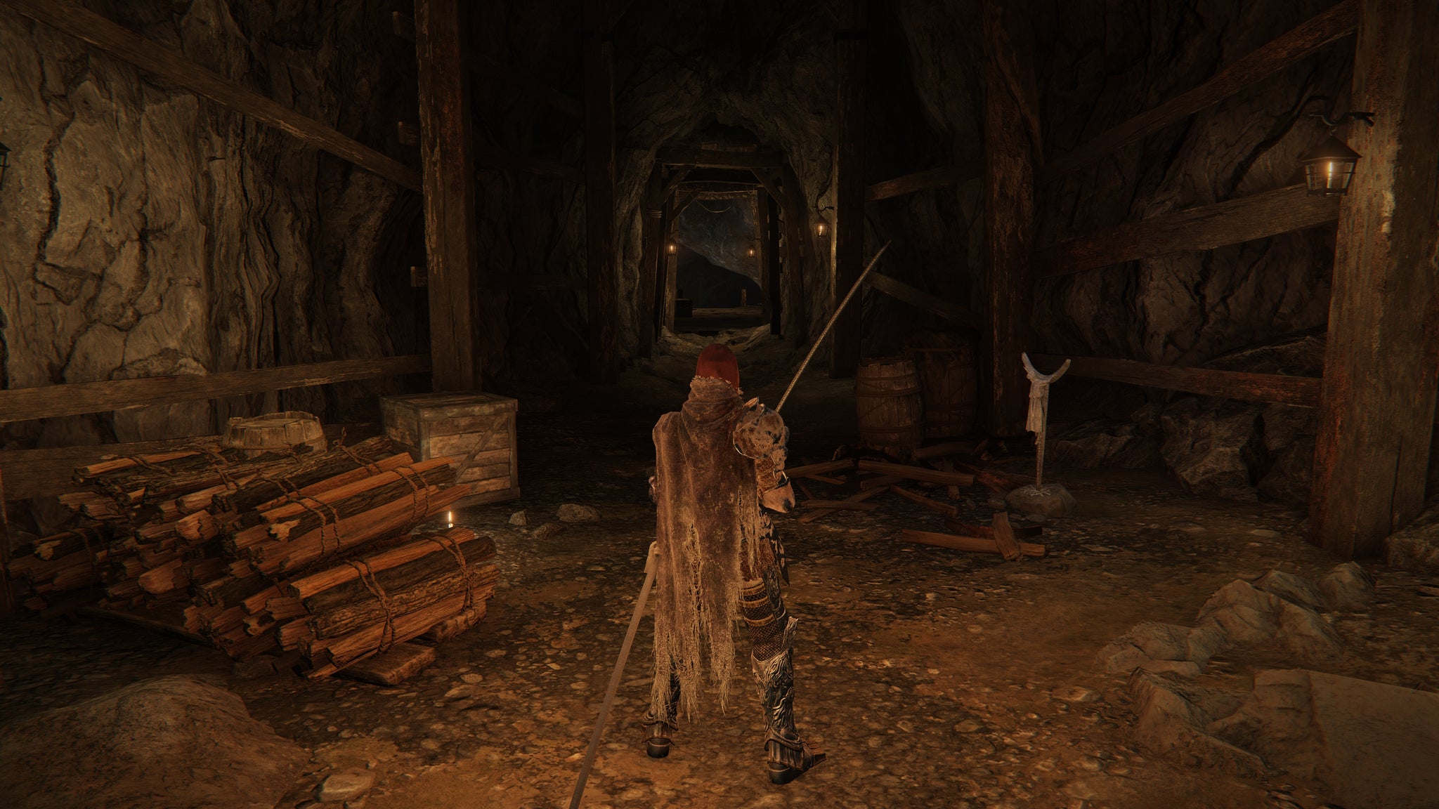 The player in Elden Ring stands at the entrance to Gael Tunnel, with their back to the camera and sword in hand. - 4