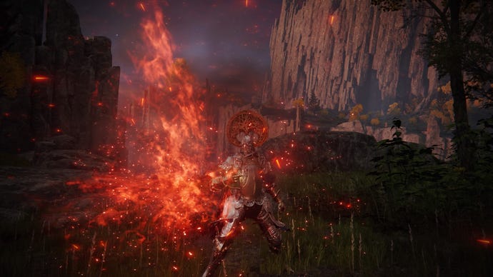 Elden Ring screenshot of the Tarnished atop a cliff, performing the Catch Flame Incantation.