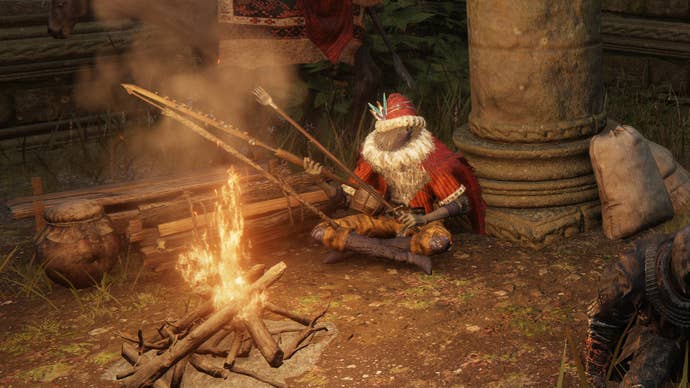 A close-up of Kale the Merchant in Elden Ring sitting next to a campfire at night.