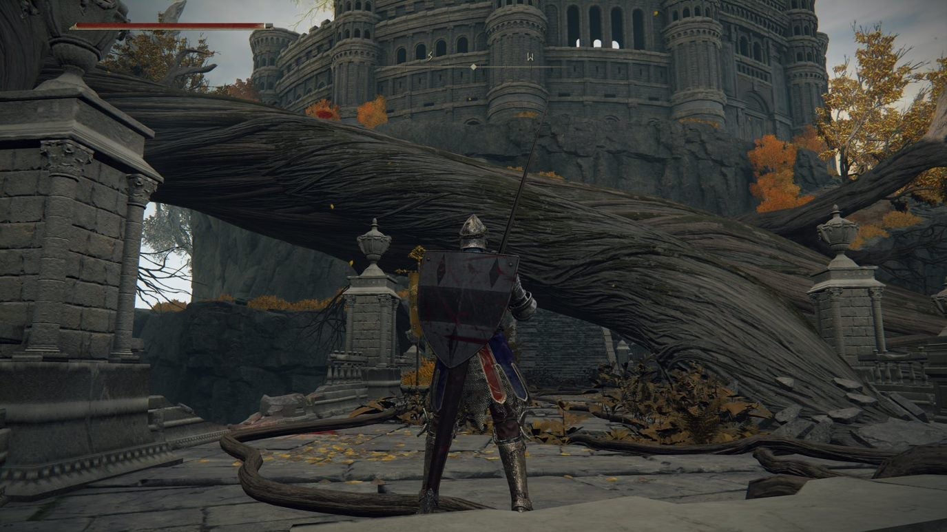 A warrior stands in front of a large tree root and colosseum in Leyndell Royal Capital in Elden Ring.