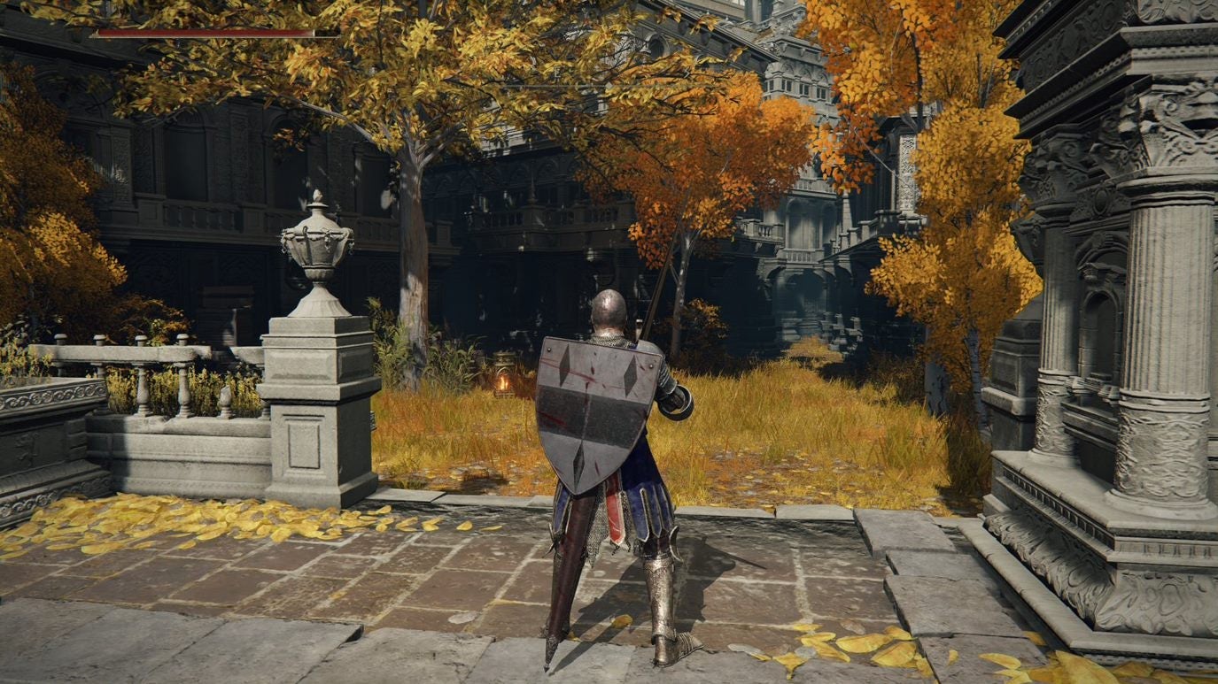 A warrior approaches an autumnal area in Leyndell, Royal Capital in Elden Ring.