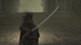The player in Elden Ring, clad in black, holds the Moonveil Katana with both hands in front of the camera.