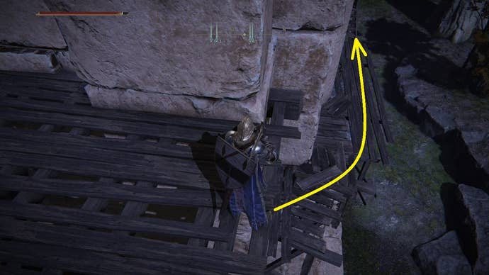A yellow arrow points towards a path round the side of a wooden scaffold in Elden Ring