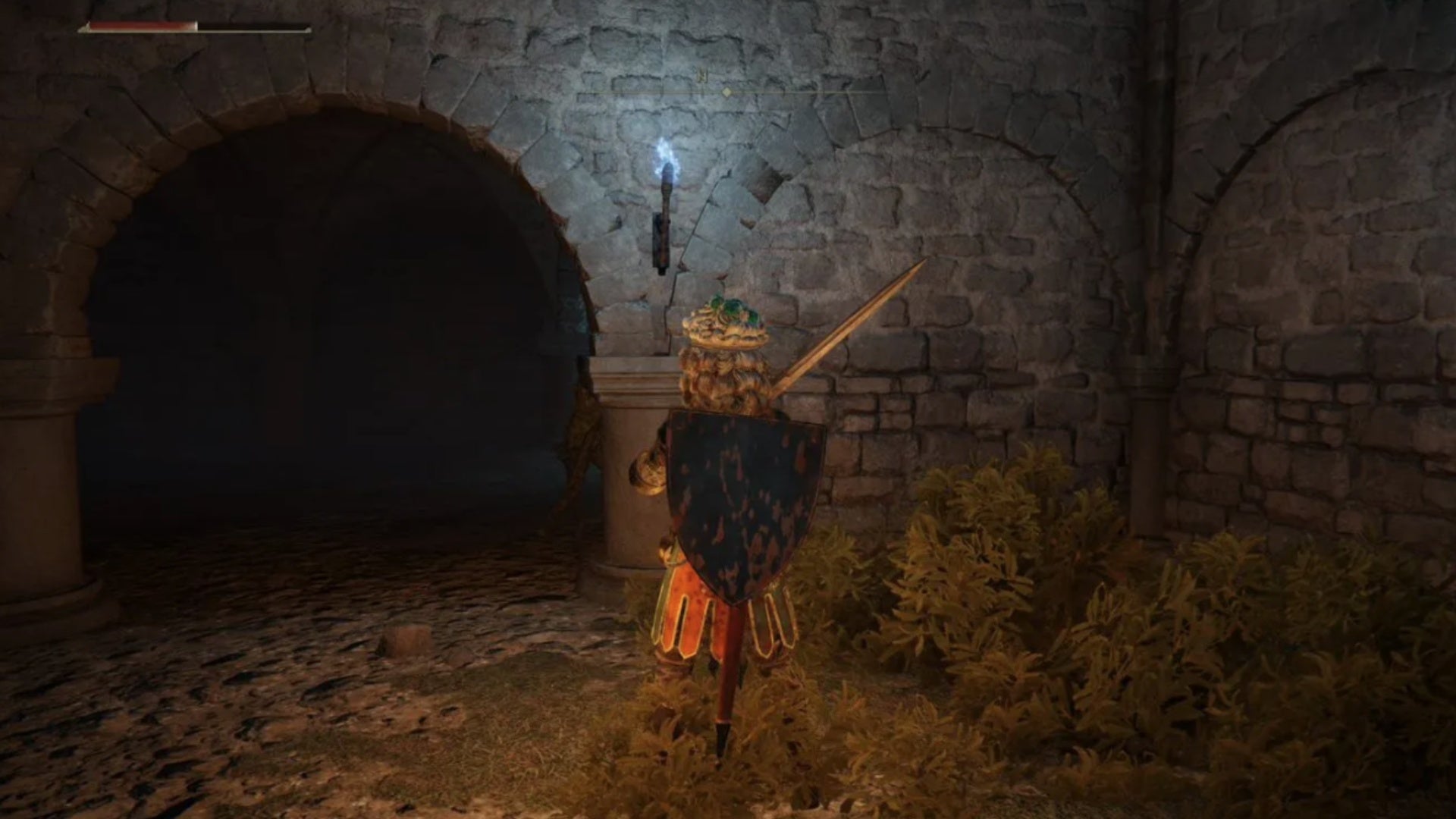 elden ring player facing secret opening in roads end catacombs