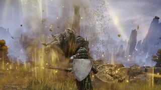 elden ring player wielding a staff while facing a large monster in a dusty environment