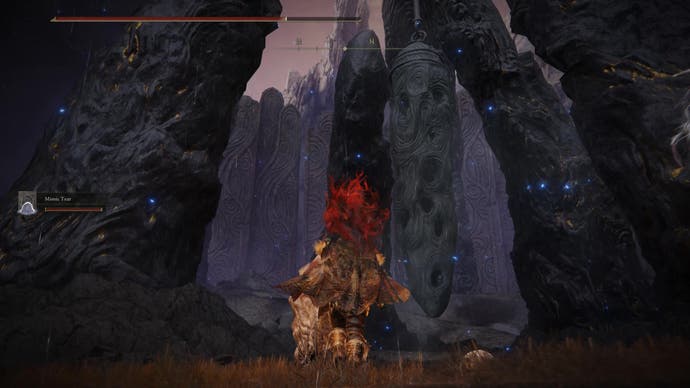 A warrior walks towards a hanging bell in the Finger Ruins of Rhia in Elden Ring Shadow of the Erdtree.