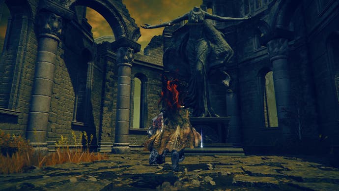 A warrior approaches a large statue in the Crusade Church as part of the Fire Knight Queelign quest in Elden Ring Shadowo of the Erdtree.