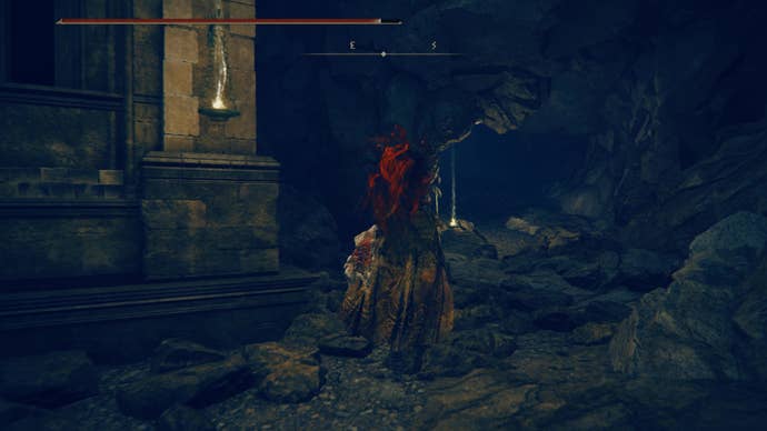 A warrior heads up a tunnel lined with torches as they travel toward the east side of the Shadow Keep in Elden Ring Shadow of the Erdtree.