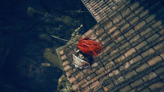 A warrior stands on the edge of a rooftop looking down a large hole as they travel toward the east side of the Shadow Keep in Elden Ring Shadow of the Erdtree.