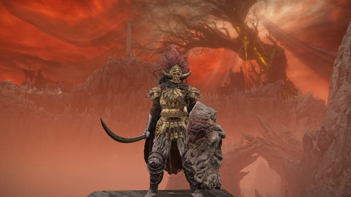 A warrior stands facing the camera against a red sky backdrop with a large twisted tree in the distance in Elden Ring Shadow of the Erdtree.