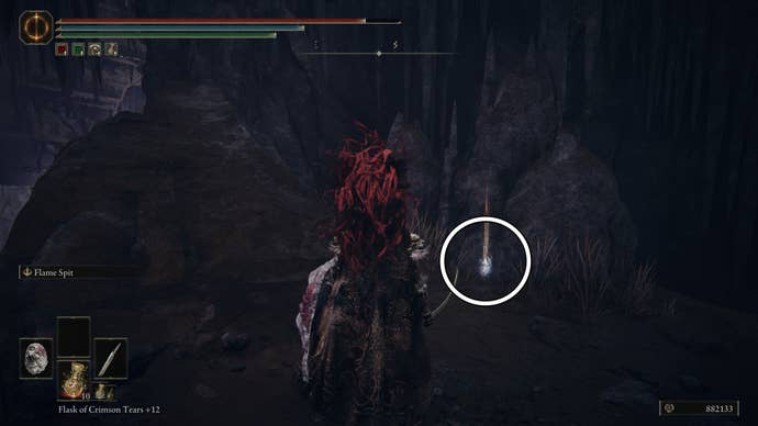 A warrior stands next to a large rock where a white circle highlights the location of the Mass of Putrescence Sorcery spell in Elden Ring Shadow of the Erdtree