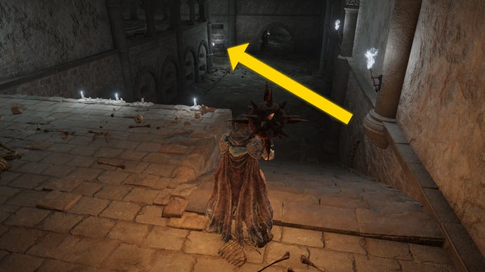 The player in Elden Ring: Shadow Of The Erdtree makes their way through the Fog Rift Catacombs, with a yellow arrow pointing towards the location of the hidden Altar.