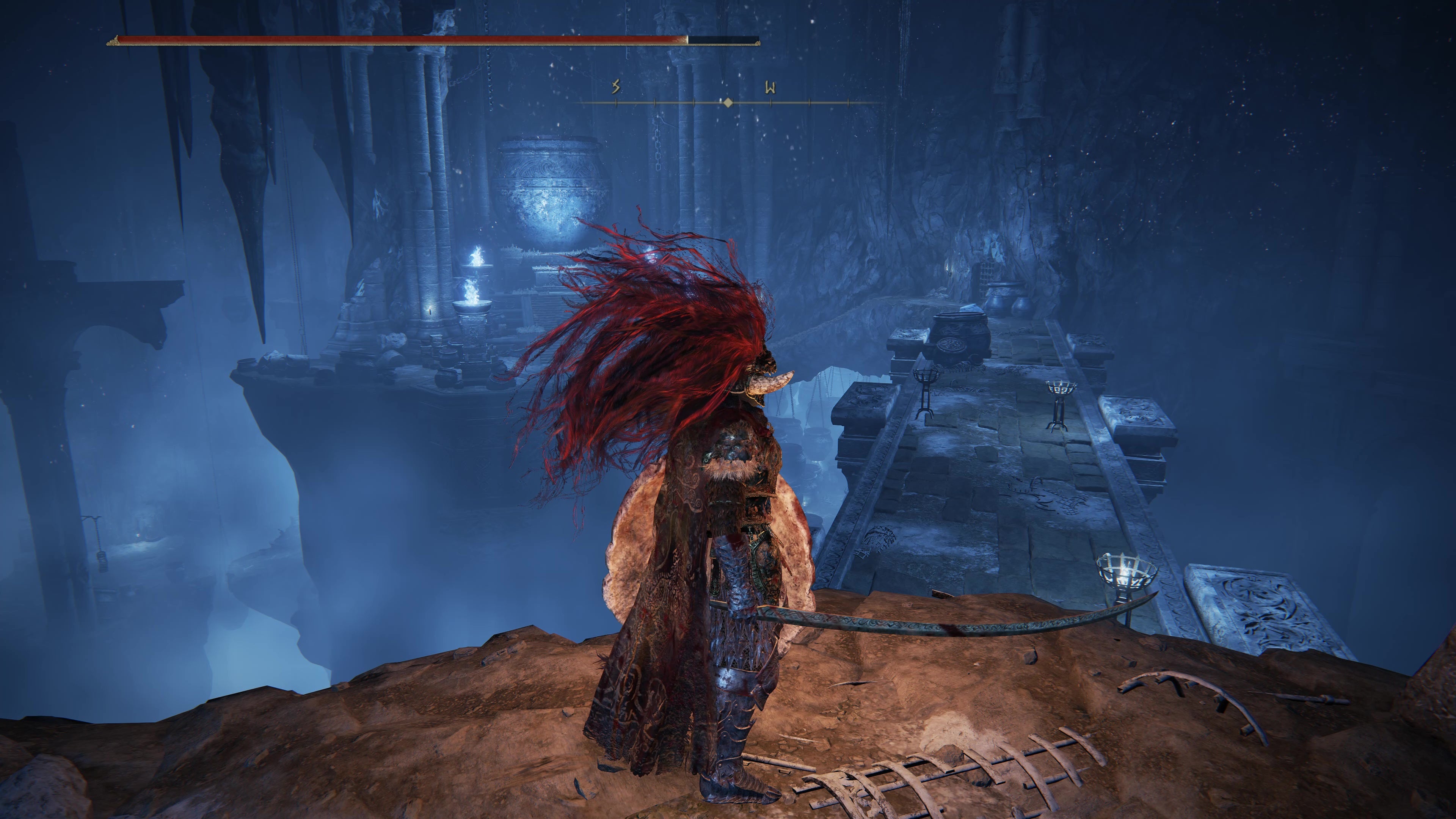 A warrior surveys a large bridge in an underground cave  in the Belurat Gaol in Shadow of the Erdtree.